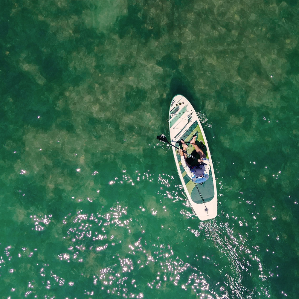Person on paddleboard on water seen from above