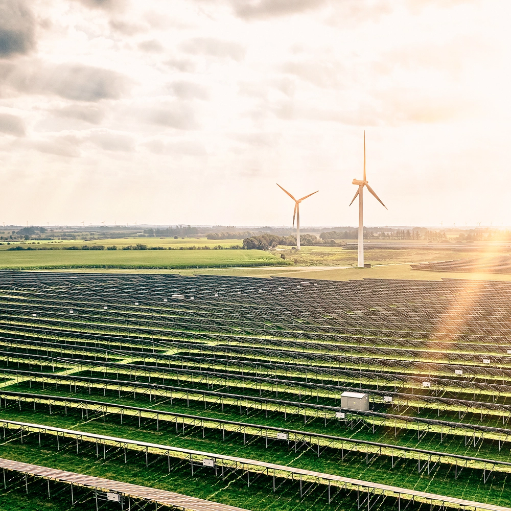 A solar farm with wind turbines under the sun